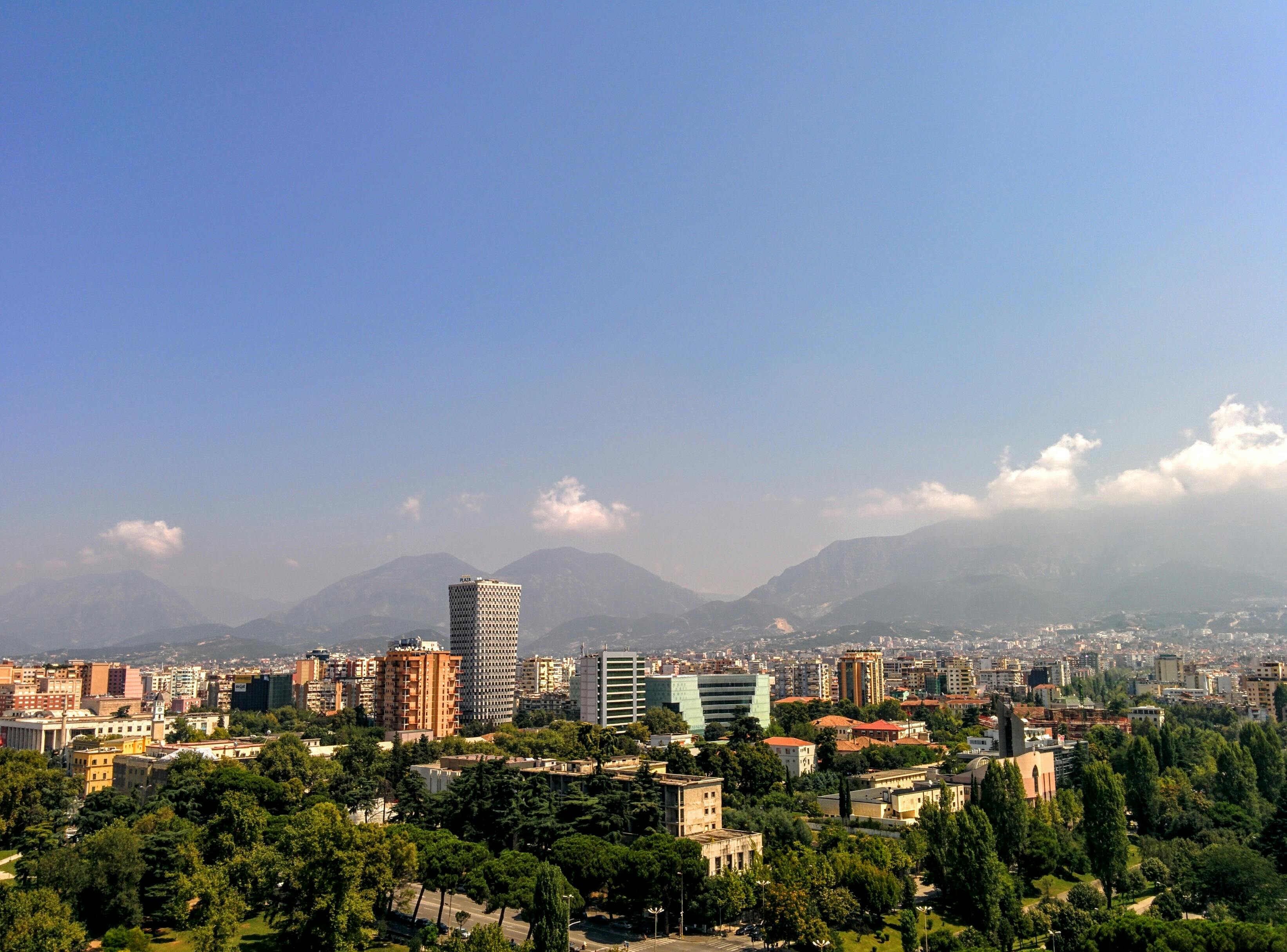 Panoramic view of Tirana with mountains in the background.